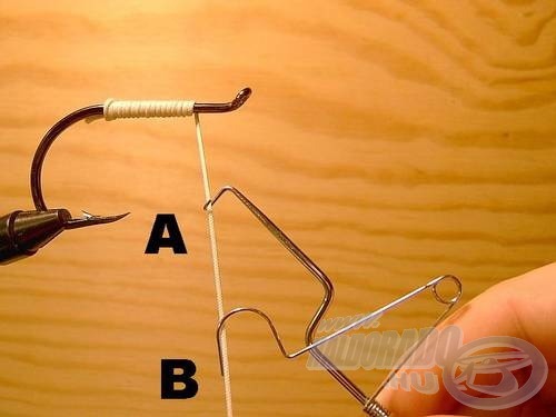 Akasszuk bele a kötöző cérnába a félcsomó kötő két szárvégét (A és B)